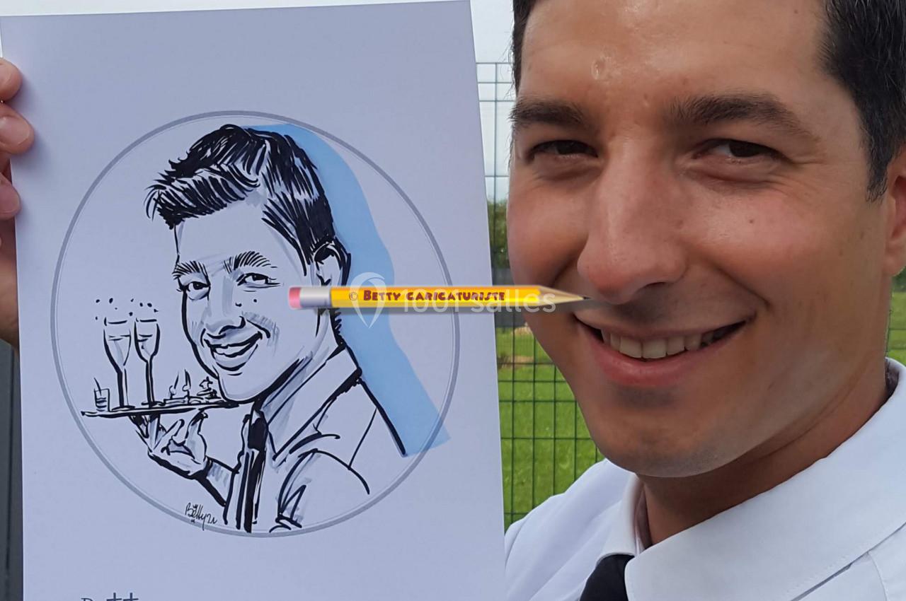 Un homme souriant tient un dessin caricatural de lui-même, réalisé avec des détails humoristiques.