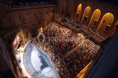Pont en pierre à arches traversant une rivière, avec des visiteurs et un ciel dégagé en arrière-plan.