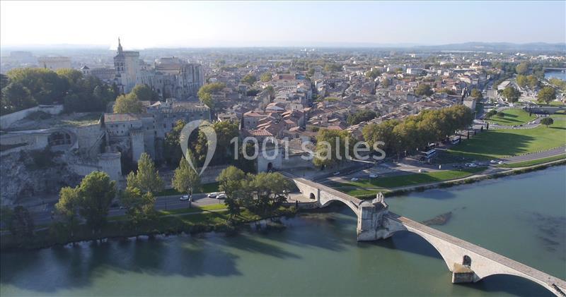 Vue aérienne d'Avignon avec le pont Saint-Bénézet traversant le Rhône et la vieille ville en arrière-plan.