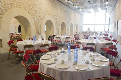Pont en pierre à arches traversant une rivière, avec des visiteurs et un ciel dégagé en arrière-plan.