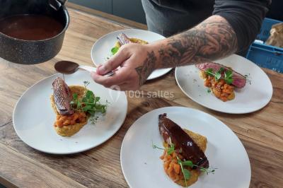 Structure gonflable colorée en forme d'arche, installée sur une cour pavée devant des maisons en briques.