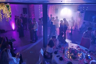 Structure gonflable colorée en forme d'arche, installée sur une cour pavée devant des maisons en briques.