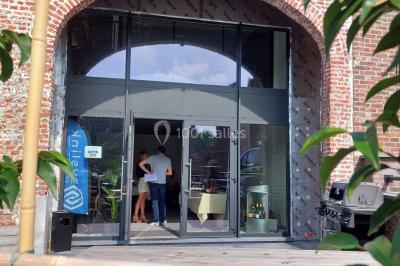 Miniature Location salle Donceel (Liège) - BCarré #12 Salle de réunion moderne avec chaises disposées en rangées, tables hautes et grandes baies vitrées laissant entrer la…