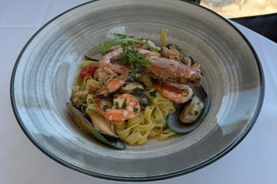 Miniature Location salle Loyettes (Ain) - Le Lion’s #26 Dessert glacé garni de fraises fraîches, de morceaux de noix et de caramel, présenté sur une assiette blanche.