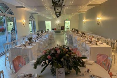 Miniature V Déco Evénements #3 Centre de table avec bouquet de fleurs blanches et roses, numéro de table ’1’ et bougies sur une nappe blanche.