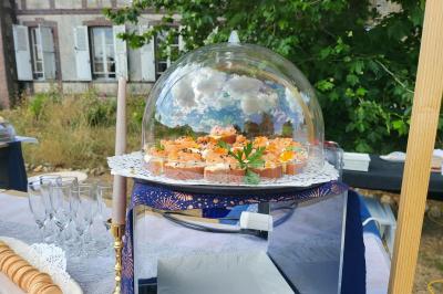 Table élégamment dressée avec nappes blanches, chaises assorties, chandeliers, fleurs roses et couverts dorés.