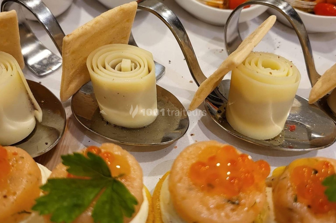 Assortiment de bouchées apéritives avec roulés de fromage, crackers et canapés au saumon et œufs de poisson.