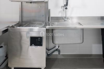 Radiateur sèche-serviettes blanc fixé sur un mur bleu, près d'un lavabo et d'étagères ouvertes.