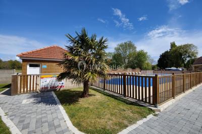 Miniature Location salle Gouville-sur-Mer (Manche) - Le Village du Phare #37 Étang entouré d'arbres illuminés la nuit, avec leurs reflets visibles sur l'eau calme.