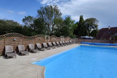 Miniature Location salle Gouville-sur-Mer (Manche) - Le Village du Phare #29 Étang entouré d'arbres illuminés la nuit, avec leurs reflets visibles sur l'eau calme.
