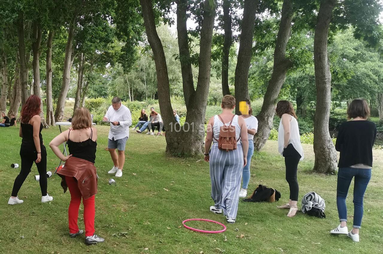 Location salle Gouville-sur-Mer (Manche) - Le Village du Phare #19 Un groupe de personnes debout dans un parc, entouré d'arbres, participant à une activité en plein air.