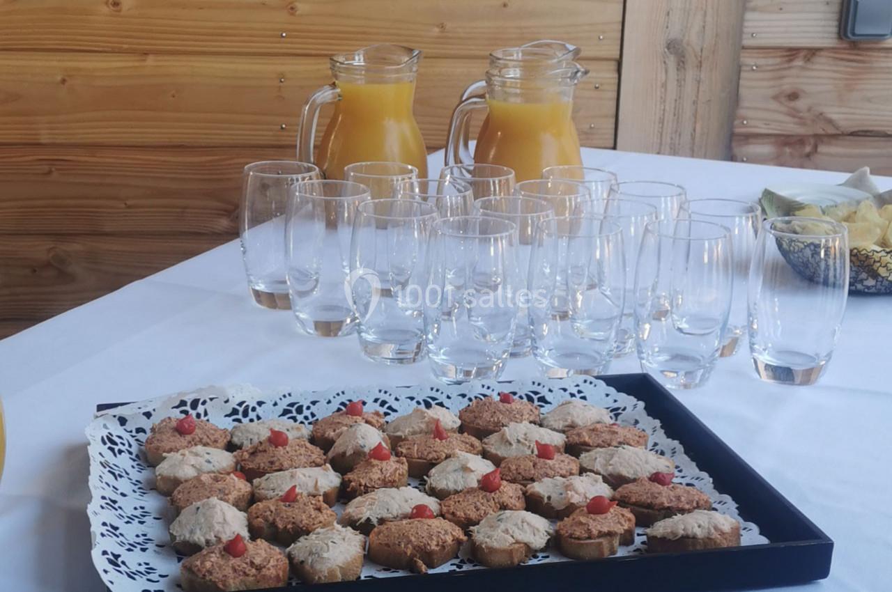 Location salle Gouville-sur-Mer (Manche) - Le Village du Phare #26 Plateau de biscuits décorés devant des verres vides et deux carafes de jus d'orange sur une table en bois.