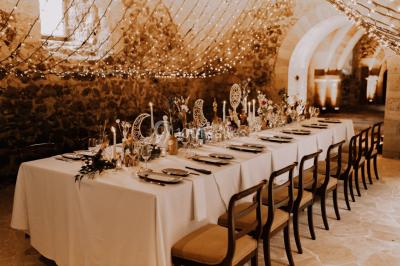 Miniature Events2gether #7 Grande table dressée en extérieur avec vaisselle, décorations florales et citrons, entourée de chaises en bois.