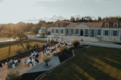 Miniature Events2gether #12 Grande table dressée en extérieur avec vaisselle, décorations florales et citrons, entourée de chaises en bois.