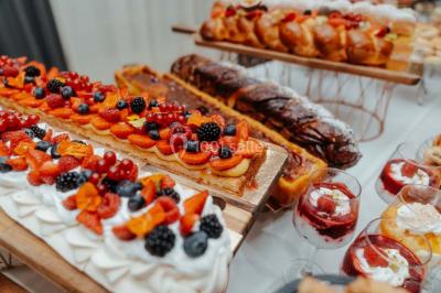 Miniature Events2gether #24 Grande table dressée en extérieur avec vaisselle, décorations florales et citrons, entourée de chaises en bois.