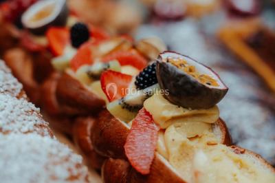 Miniature Events2gether #26 Grande table dressée en extérieur avec vaisselle, décorations florales et citrons, entourée de chaises en bois.