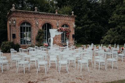 Miniature Events2gether #28 Grande table dressée en extérieur avec vaisselle, décorations florales et citrons, entourée de chaises en bois.