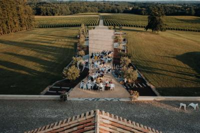 Miniature Events2gether #36 Grande table dressée en extérieur avec vaisselle, décorations florales et citrons, entourée de chaises en bois.