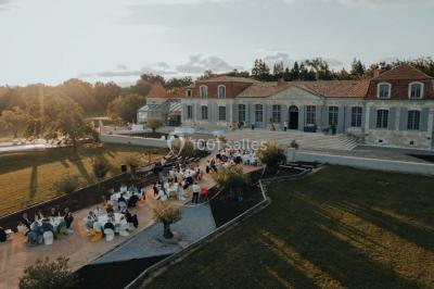 Miniature Events2gether #37 Grande table dressée en extérieur avec vaisselle, décorations florales et citrons, entourée de chaises en bois.