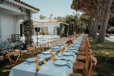 Miniature Events2gether #43 Grande table dressée en extérieur avec vaisselle, décorations florales et citrons, entourée de chaises en bois.