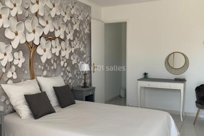 Miniature Location salle Lambesc (Bouches-du-Rhône) - Villa Maya Provence #20 Salle lumineuse avec tables rectangulaires, chaises noires et verrerie suspendue, donnant sur de grandes fenêtres.