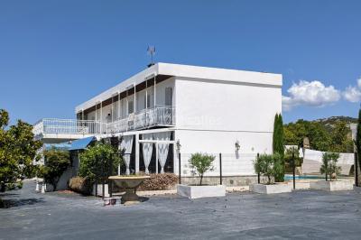 Miniature Location salle Lambesc (Bouches-du-Rhône) - Villa Maya Provence #17 Salle lumineuse avec tables rectangulaires, chaises noires et verrerie suspendue, donnant sur de grandes fenêtres.