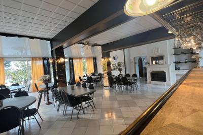 Miniature Location salle Lambesc (Bouches-du-Rhône) - Villa Maya Provence #25 Salle lumineuse avec tables rectangulaires, chaises noires et verrerie suspendue, donnant sur de grandes fenêtres.