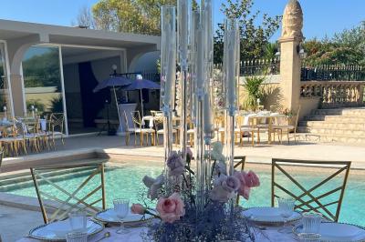 Miniature Location salle Lambesc (Bouches-du-Rhône) - Villa Maya Provence #5 Salle lumineuse avec tables rectangulaires, chaises noires et verrerie suspendue, donnant sur de grandes fenêtres.