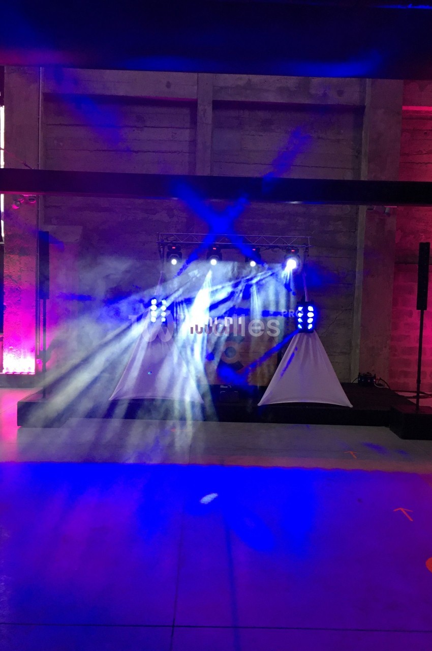 Jeux de lumière colorés projetés sur une scène dans un espace intérieur avec murs en béton.