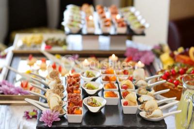 Plateaux de bouchées apéritives variées comprenant canapés, roulés, mini-brochettes et tartines décorées.
