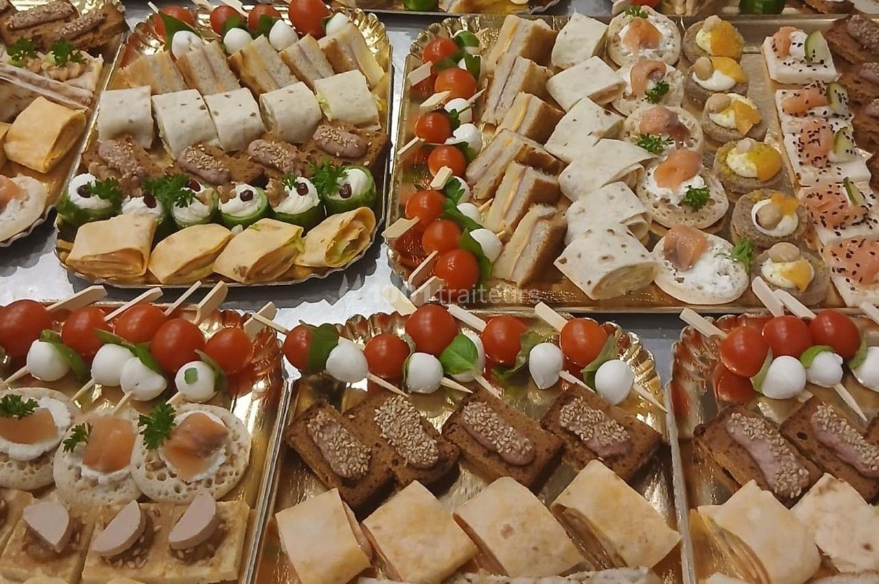 Plateaux de bouchées apéritives variées comprenant toasts, wraps, brochettes et mini-sandwichs.