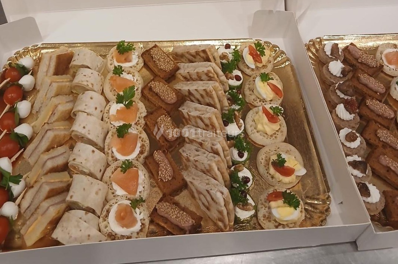 Plateaux de bouchées apéritives variées comprenant canapés, roulés, mini-brochettes et tartines décorées.