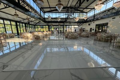 Un groupe de personnes en tenue traditionnelle célèbre un événement sous des lustres dans une grande salle éclairée.
