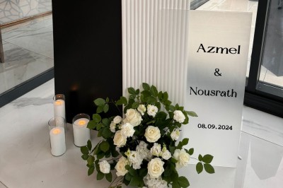 Un groupe de personnes en tenue traditionnelle célèbre un événement sous des lustres dans une grande salle éclairée.