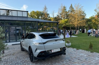 Un groupe de personnes en tenue traditionnelle célèbre un événement sous des lustres dans une grande salle éclairée.