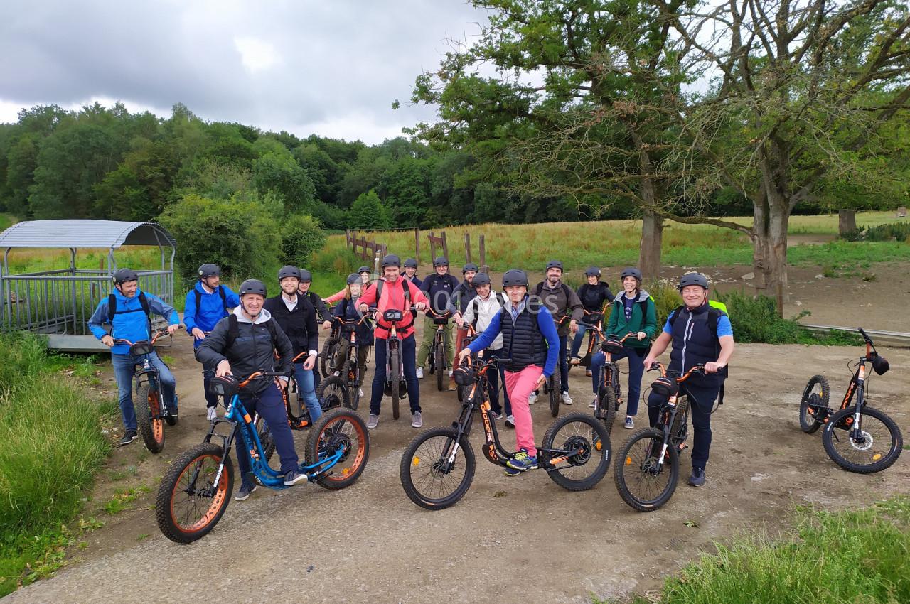 Photo Natura Parc #8 Un groupe de personnes en trottinettes tout-terrain posant sur un chemin en pleine nature.