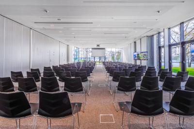 Miniature Location salle Froidchapelle (Hainaut) - Golden Lakes Hôtel #8 Terrasse en bois avec table et chaises, vue sur un jardin verdoyant et un lac au coucher du soleil.