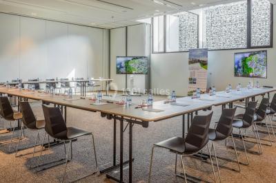 Miniature Location salle Froidchapelle (Hainaut) - Golden Lakes Hôtel #14 Terrasse en bois avec table et chaises, vue sur un jardin verdoyant et un lac au coucher du soleil.