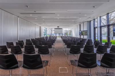 Miniature Location salle Froidchapelle (Hainaut) - Golden Lakes Hôtel #16 Terrasse en bois avec table et chaises, vue sur un jardin verdoyant et un lac au coucher du soleil.