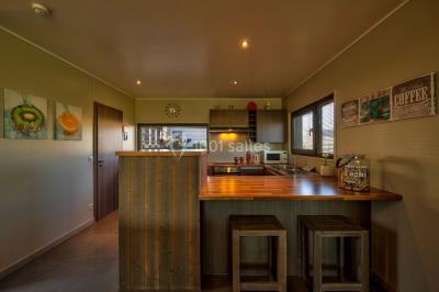 Miniature Location salle Froidchapelle (Hainaut) - Golden Lakes Hôtel #24 Terrasse en bois avec table et chaises, vue sur un jardin verdoyant et un lac au coucher du soleil.