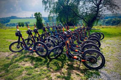 Miniature Location salle Froidchapelle (Hainaut) - Le Refuge du Badon #17 Dépliant sur des trottinettes électriques tout terrain posé sur une table avec viennoiseries et jus d'orange en arrière-plan.