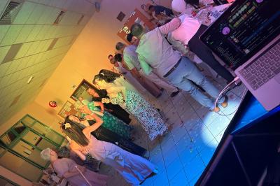 Miniature DJ Geville (Meuse) - Team MooMa Events #14 Des personnes dansent dans une salle éclairée par des lumières rouges, entourées de tables dressées pour un événement.