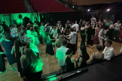 Miniature DJ Geville (Meuse) - Team MooMa Events #11 Des personnes dansent dans une salle éclairée par des lumières rouges, entourées de tables dressées pour un événement.