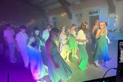 Miniature DJ Geville (Meuse) - Team MooMa Events #31 Des personnes dansent dans une salle éclairée par des lumières rouges, entourées de tables dressées pour un événement.