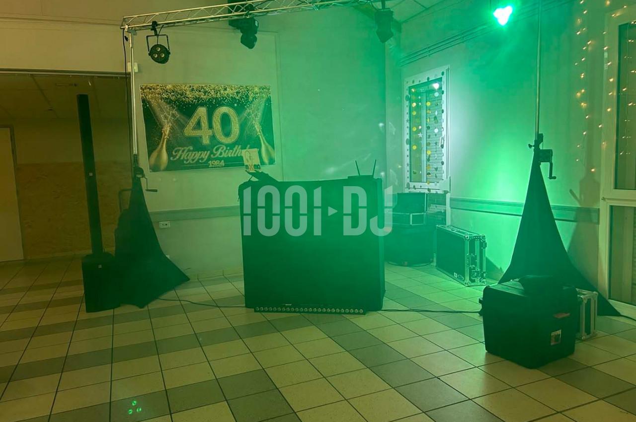 Installation de matériel de sonorisation et d'éclairage avec une bannière ’40’ dans une salle décorée.