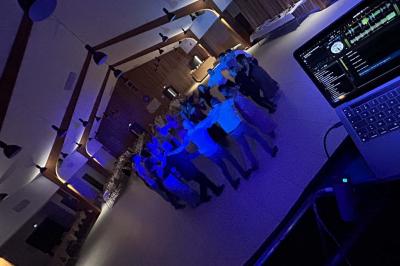 Miniature DJ Geville (Meuse) - Team MooMa Events #24 Des personnes dansent dans une salle éclairée par des lumières rouges, entourées de tables dressées pour un événement.