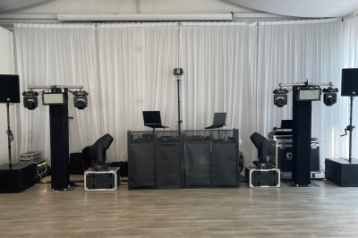 Installation de matériel de sonorisation et d'éclairage avec projecteurs et enceintes dans une salle de réception.