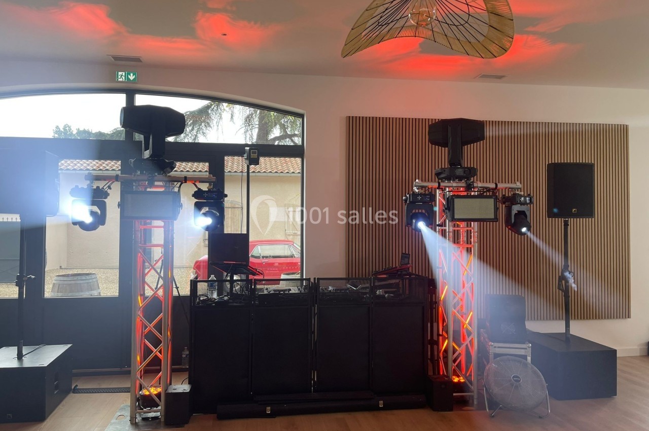 Installation de matériel de sonorisation et d'éclairage avec projecteurs et enceintes dans une salle lumineuse.