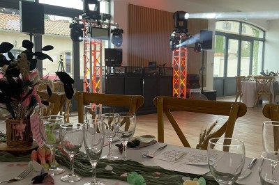 Installation de matériel de sonorisation et d'éclairage avec projecteurs et enceintes dans une salle de réception.