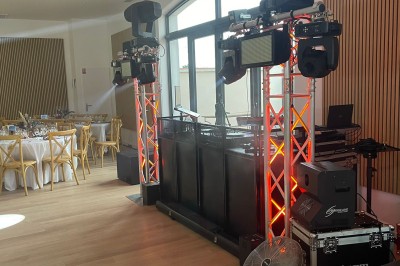 Installation de matériel de sonorisation et d'éclairage avec projecteurs et enceintes dans une salle de réception.